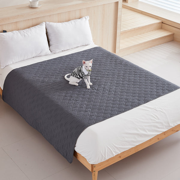 Dark gray quilted pet blanket with a cat sitting on it